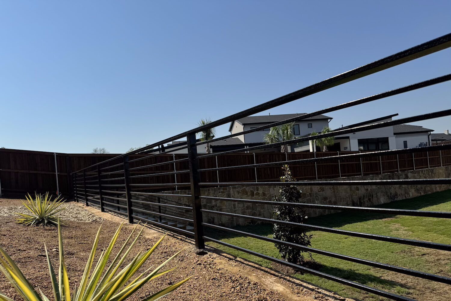 Iron fencing around platform by Gladiator Fence & Outdoors